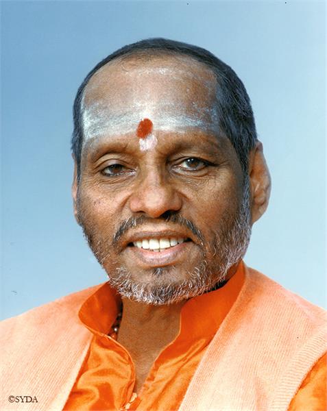Close up of baba with ash and bindi on forehead, against a light blue background