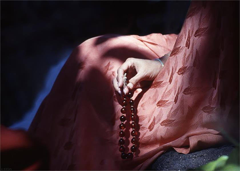 Close up of Gurumayis hands holding a japa mala over pink robes