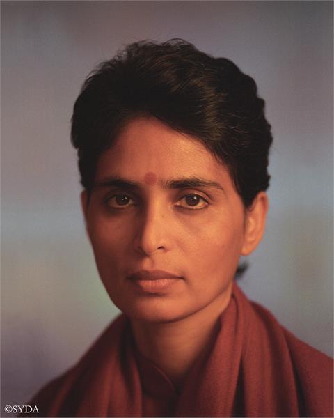 Close up of Gurumayi against a grey and blue background