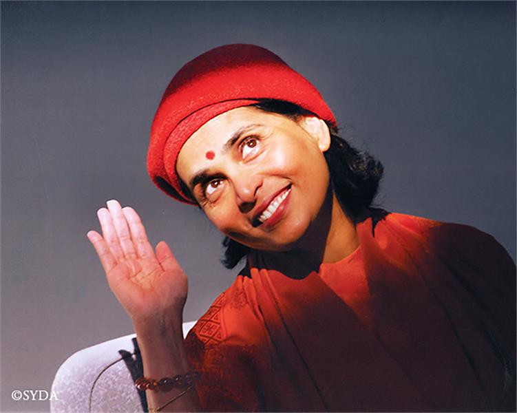 Gurumayi smiling and waving hand to the sun