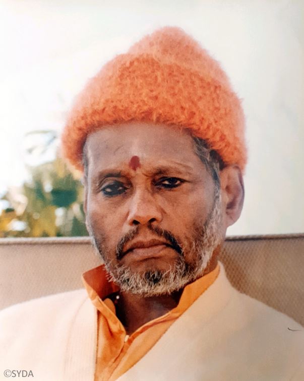Close up of baba sitting outside in an orange hat